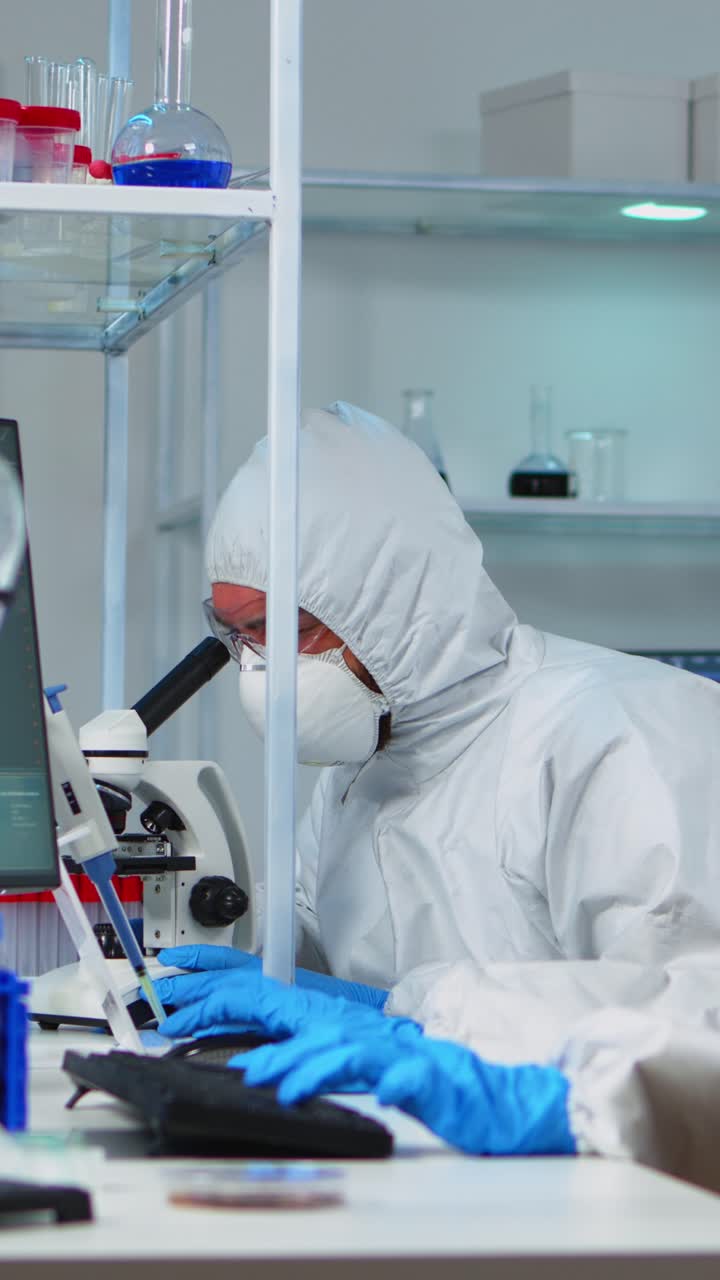 Vertical video: Scientists in protection suits working in chemical lab