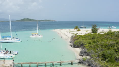 yachts in boat docks with tourists enjoying cayo icacos beach - aerial