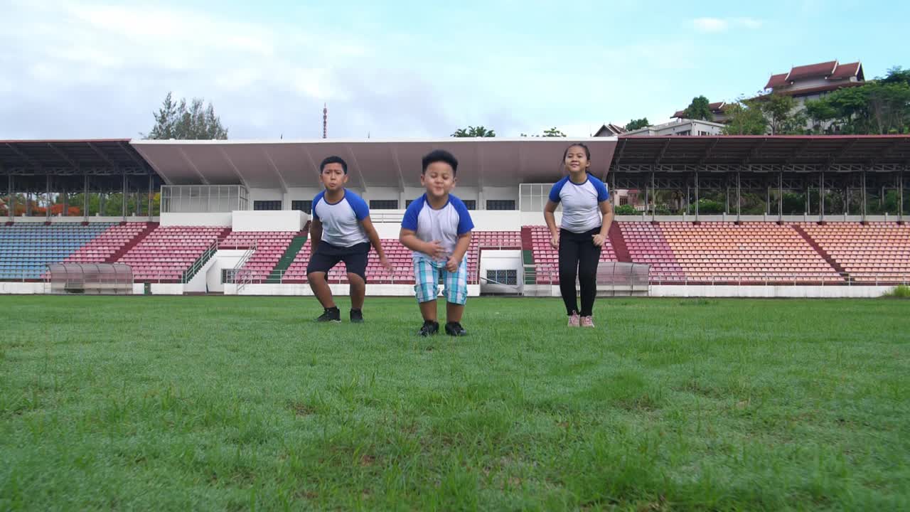 Asian Children Jumping At Stadium
