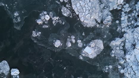 Overhead-aerial-view-of-floating-iceberg-in-water,-Alaska,-USA