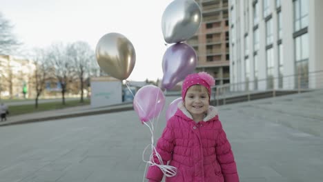 Glückliches-Kind-Läuft-Mit-Heliumballons-Die-Straße-Entlang