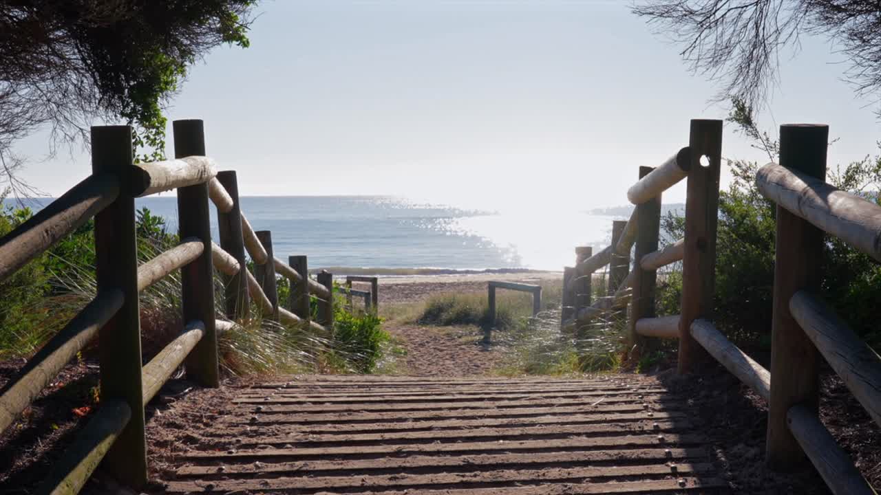 A fenced beach access path onto Tathra beach during a sunny morning, Australia