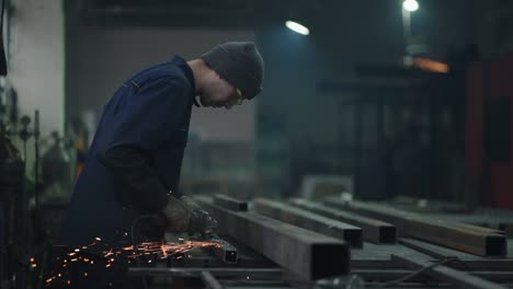 trabajador de la industria pesada que corta acero con una molienda angular. trabajador manual de la indústria pesada