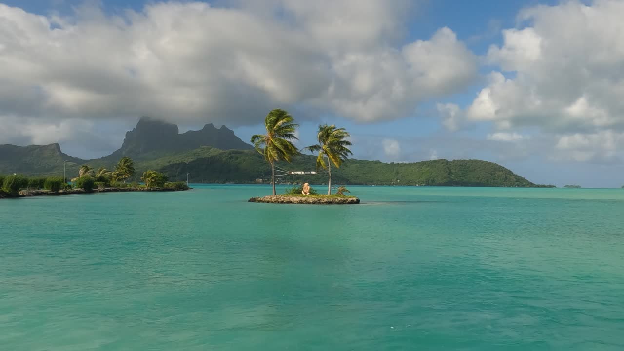 Tropical island with palm trees and turquoise water in Bora Bora