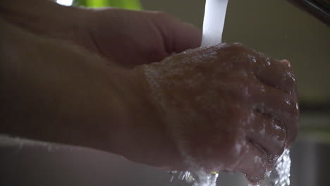 prevention coronavirus close up of man placing hands under running water and hand washing in sink