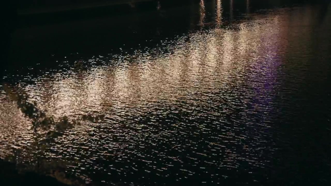Ljus reflekteras i floden på natten