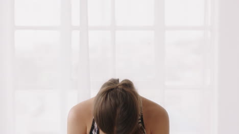 hermosa mujer caucásica practicando yoga sentado oración pose meditación disfrutando de un estilo de vida saludable en casa estirando el cuerpo flexible