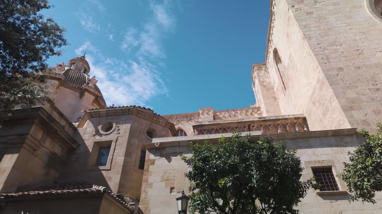 Historic Tarragona Cathedral with a detailed rose window under clear blue skies in Spain