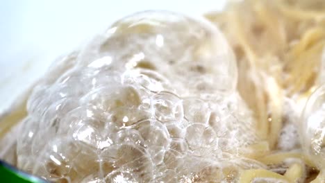 boiling water with spaghetti noodles in the steel pan, loop