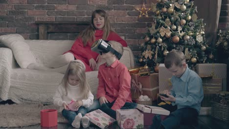 nice lady looks at children playing and opening gifts