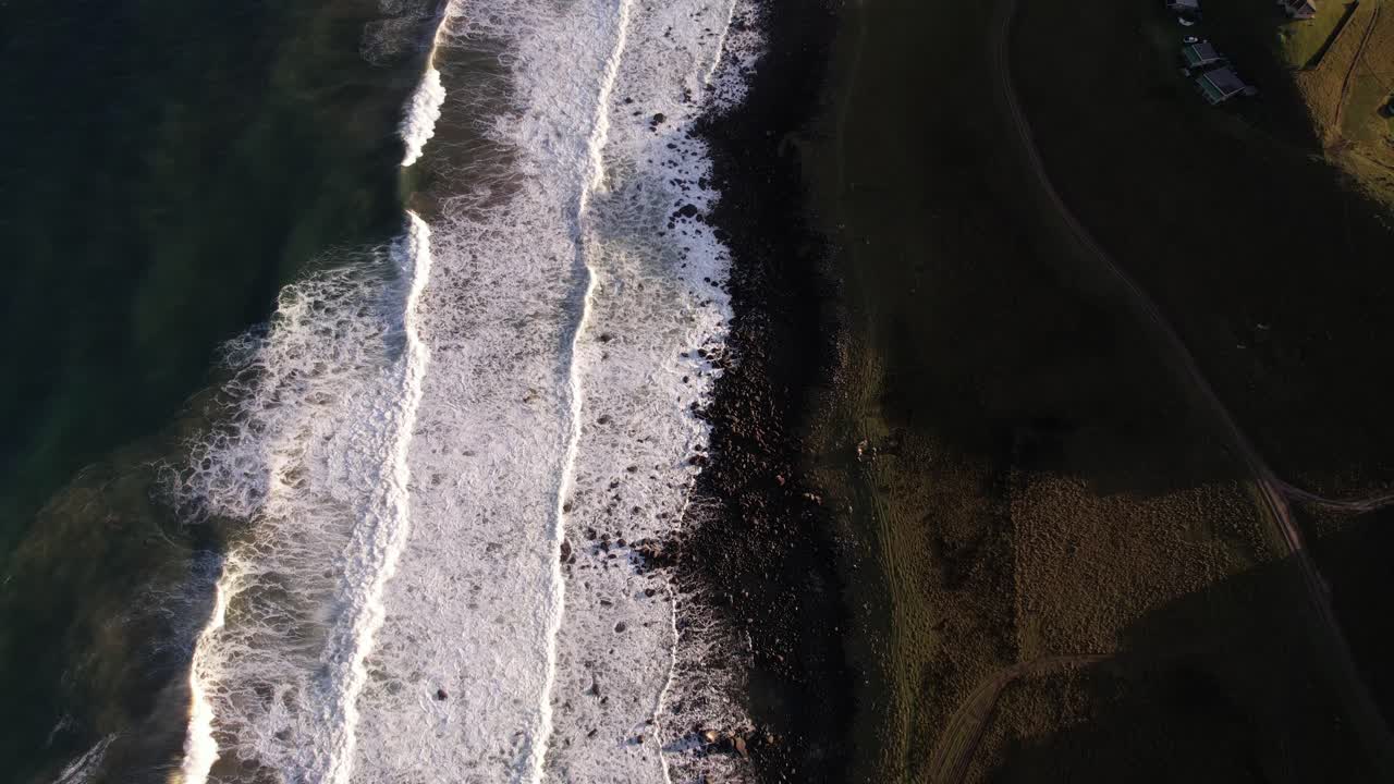 Aerial View of Ocean Waves Crashing on Rocky Coastline