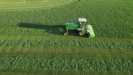 in door county, wi, a farmer on a john deere tractor, cuts his alfalfa field in late august-16