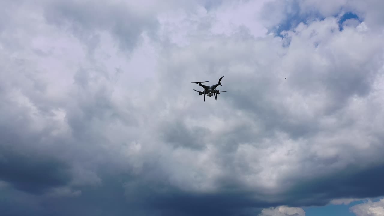 Flying drone over fields. Drone capturing aerial shots using camera against a blue sky