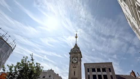 clock tower under a bright, cloudy sky