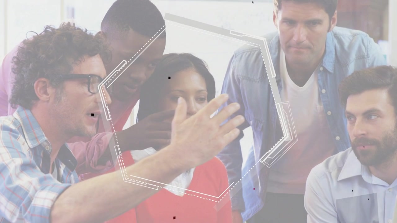 Design team around laptop, speaker gesturing, initiating hex overlays aligning with hand for review