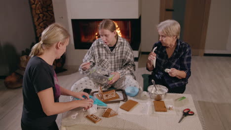 familia haciendo casas de pan de jengibre junto a la chimenea