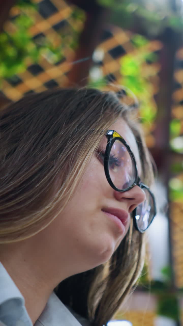 primer plano de un trabajador remoto conversando por teléfono con un cliente extranjero en un espacio de trabajo moderno con vegetación, destacando la comunicación digital, el entorno profesional y la colaboración virtual