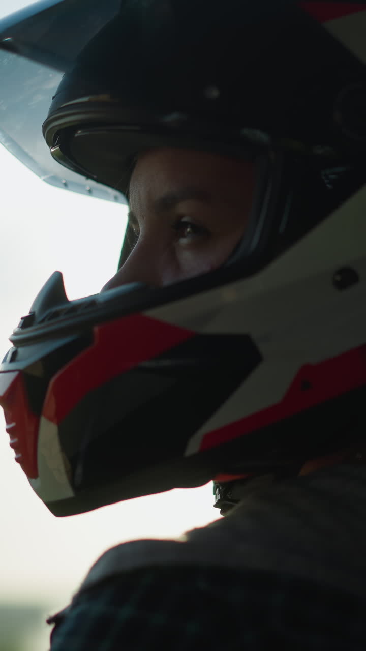 vista de la cabeza de una dama con un casco, con los rayos del sol reflejados a través de la visera mientras mira hacia la derecha