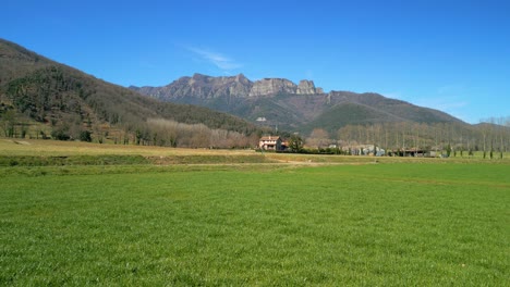 Spektakuläres-Bild-Der-Garrotxa-Auf-Einem-Bewirtschafteten-Grünen-Feld-Und-Bergen-Im-Hintergrund-In-Girona,-Spanien,-Europäischer-Tourismus.-Streichen-Sie-Nach-Rechts