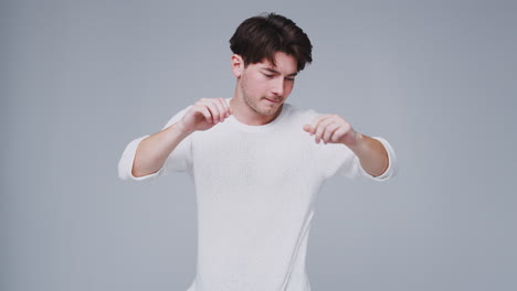 wide angle studio shot of young man against white background dancing in slow motion