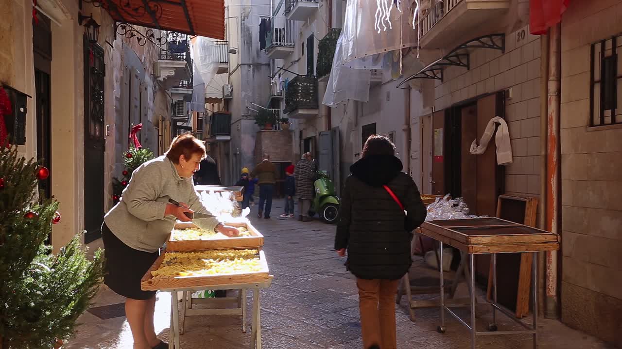 Local people on a narrow beautiful street in Bari, Italy
