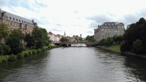 rhine river in city centre of strasbourg with tram passing a bridge