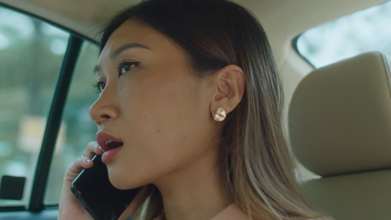 Asian Businesswoman Having Phone Talk in Taxi