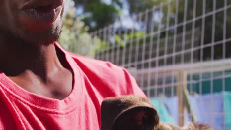 african american volunteer man in a dog shelter with a puppy