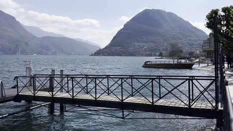 lake landscape with tourists on a pedal boat and people having a walk