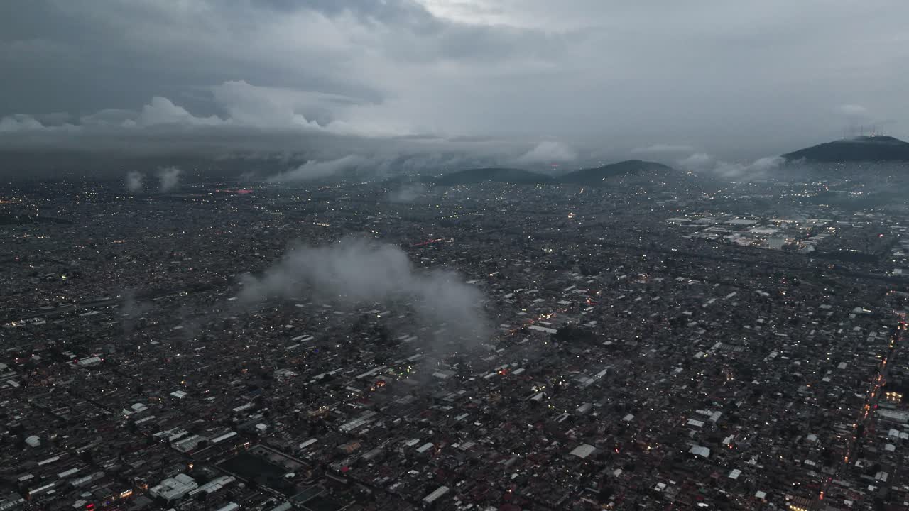 Drone pierces low clouds over Ecatepec's urban landscape