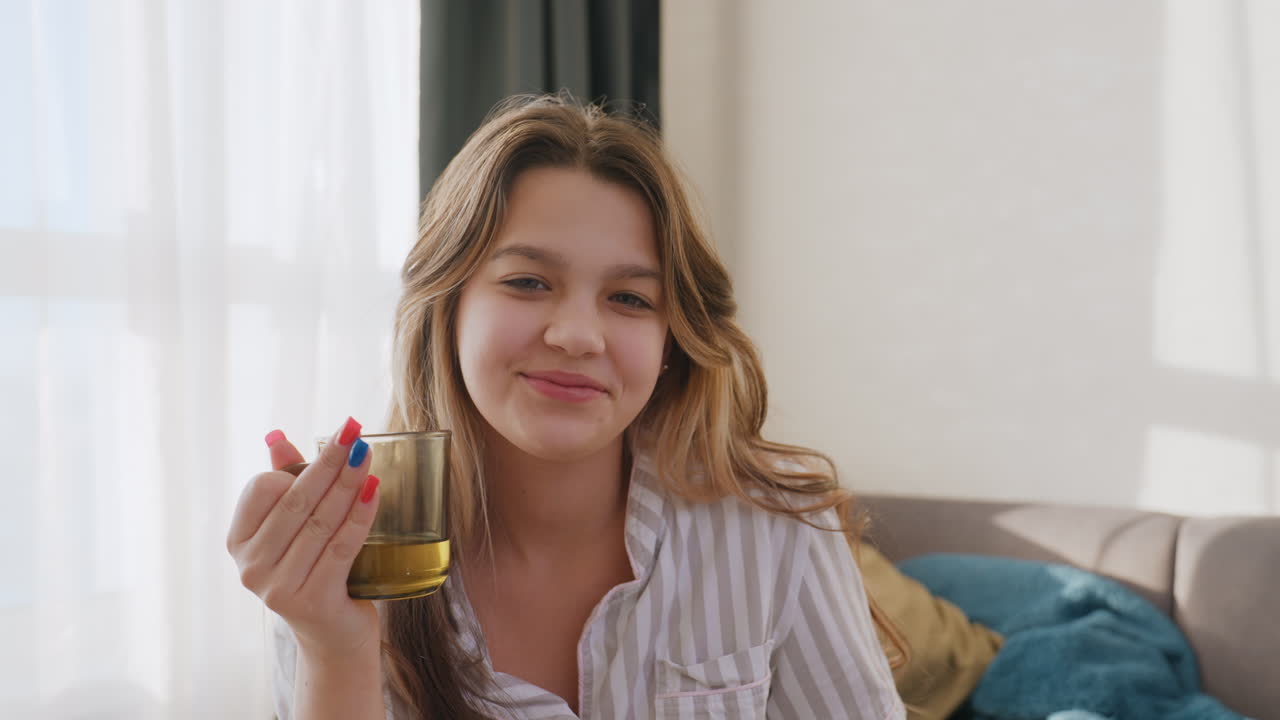 Joyful Woman Relaxing, Young Lady Sipping Drink Near Window, Cheerful Woman Seated Comfortably With Mug And Bright Smile, Casual Young Woman Engaging Happily With Beverage Beside Sunlit Window