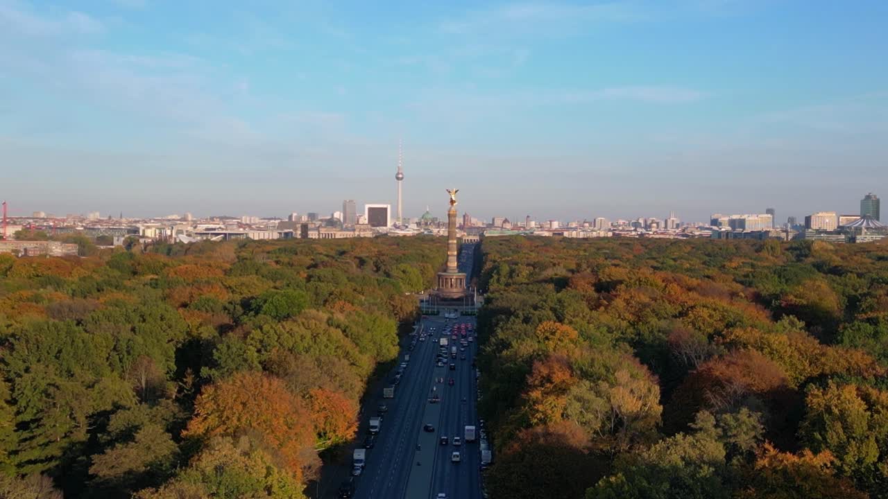 iconic landmark surrounded by colorful autumn foliage, with the cityscape in the background under a clear blue sky. Amazing aerial view flight descending drone