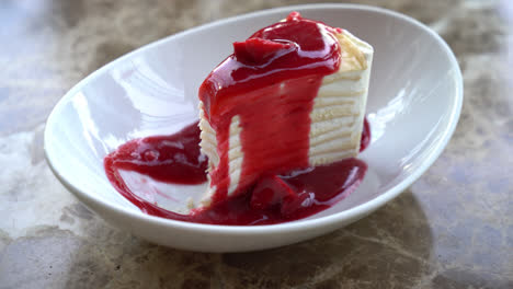 vanilla crepe cake with raspberry and strawberry sauce on plate