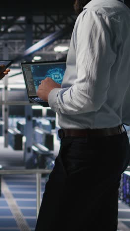 vertical video data center team leader and worker reviewing performance dashboards of ai
