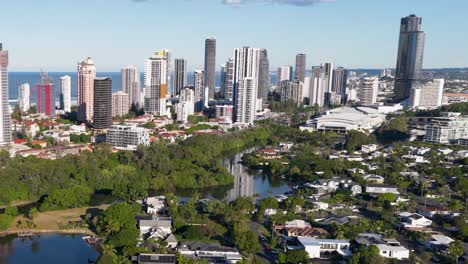 aerial footage captures gold coast's skyline and lush suburbs under clear skies, showcasing urban and natural landscapes