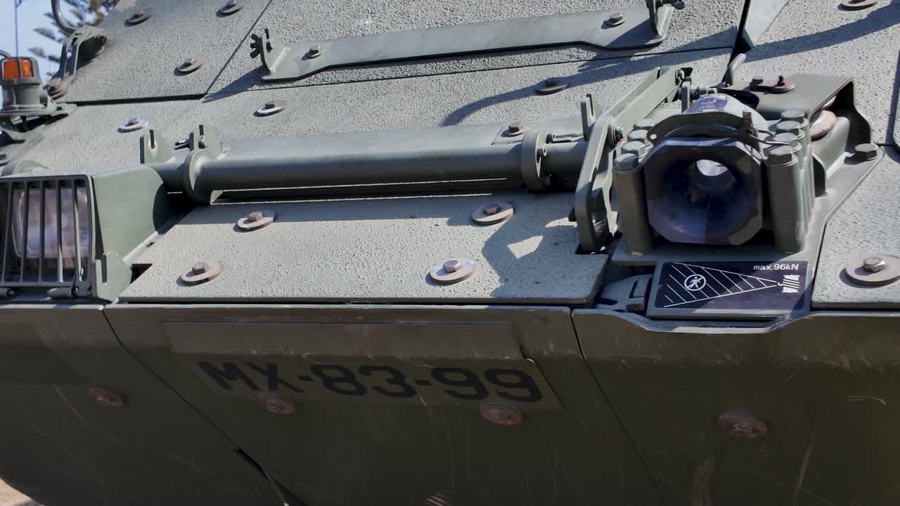 Close up view of a smoke discharger system mounted on the side of an armored vehicle, enhancing its defensive capabilities