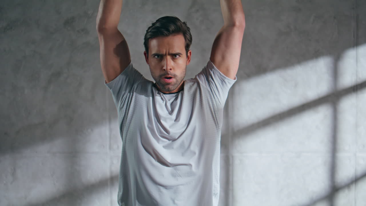 Powerlifter training hands strength lifting weight plate at grey studio closeup