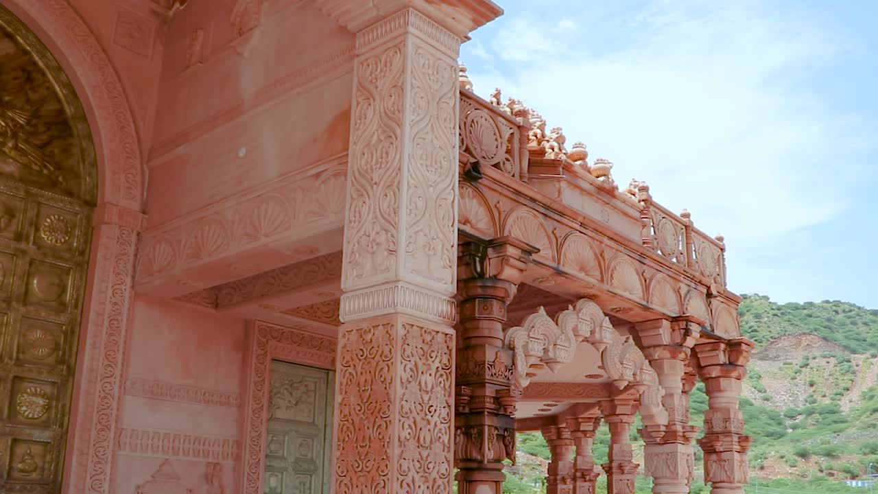 artístico templo jainista de piedra roja tallada a mano por la mañana desde un ángulo único el video se toma en shri digamber jain gyanoday tirth kshetra, nareli jain mandir, ajmer, rajasthan, india