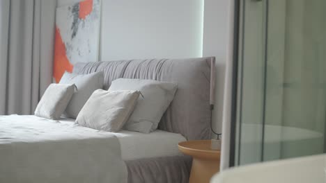 modern bedroom interior design and decoration with white and grey bedding sheet, white chair, night light headboard.