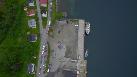 Toma-Aérea-Reveladora-De-Una-Larga-Cola-De-Automóviles-Estacionados-En-La-Ruta-Panorámica-De-Senja-En-El-Puerto-De-Ferry-De-Gryllefjord.