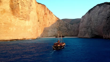 Drone-footage-of-Navagio-Beach-with-a-cruise-ship-full-of-tourists-in-the-foreground