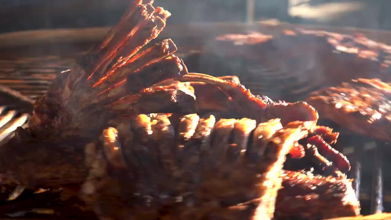 Primo piano di costine saporite che grigliano su un barbecue fumante