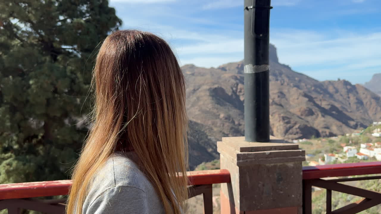 Tourist observing Roque Bentayga from Tejeda village from a viewpoint in Gran Canaria