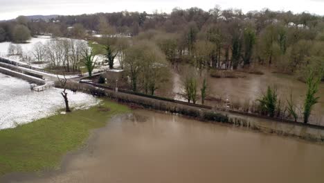 aerial footage from drone showing the river bollin in wilmslow, cheshire after heavy rain and with burst banks and flooding surrounding area