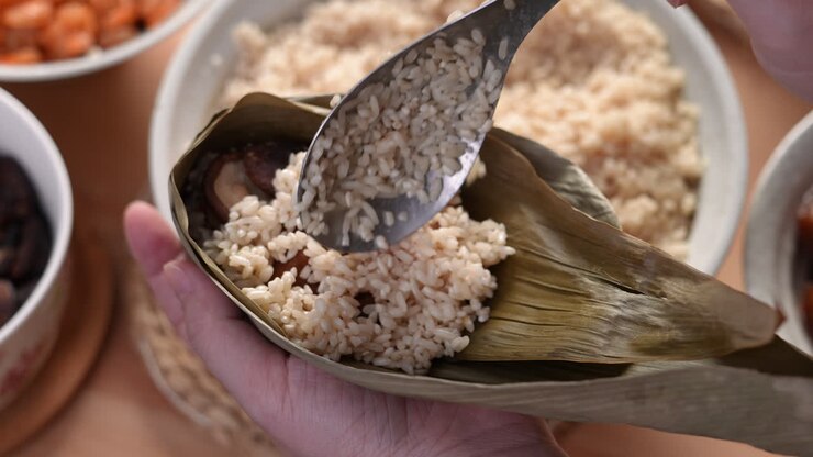 Making zongzi food - preparing and wrapping Chinese rice dumpling.