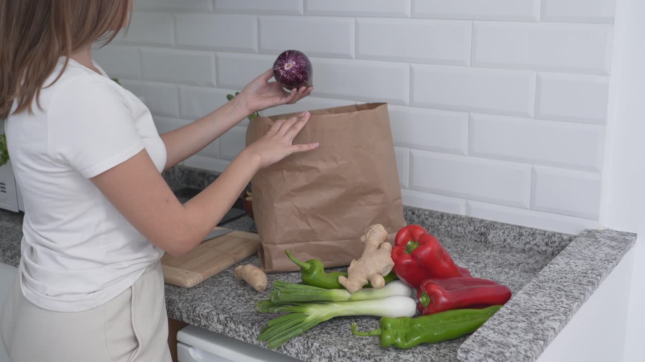 mujer desempaquetando comestibles en la cocina