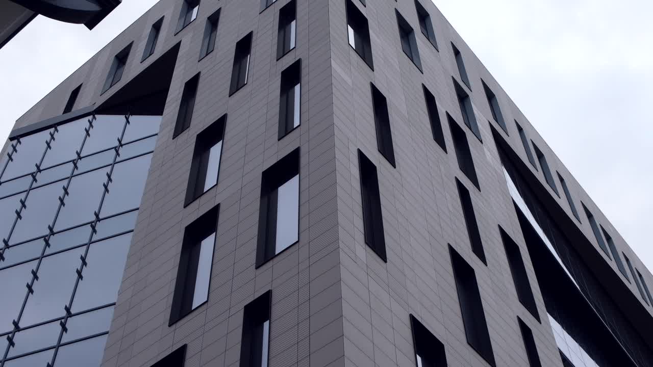 Low angle view of a grey building with multiple windows