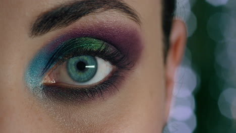 close up macro woman eye opening wearing colorful makeup new years eve party celebration concept