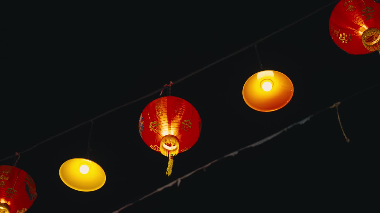 Lanternas chinesas vermelhas tradicionais e lâmpadas amarelas brilhando na escuridão
