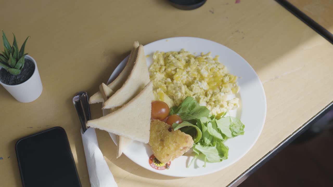 Healthy vegan morning breakfast of baked egg, bread, tomatoes and salad, close up